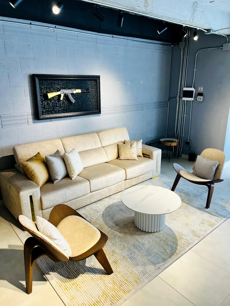 Sala con sofá beige, butacas y chimenea